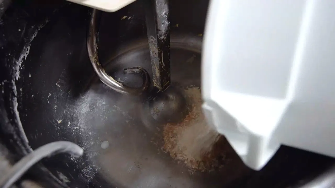 Flour going into a large steel mixing bowl