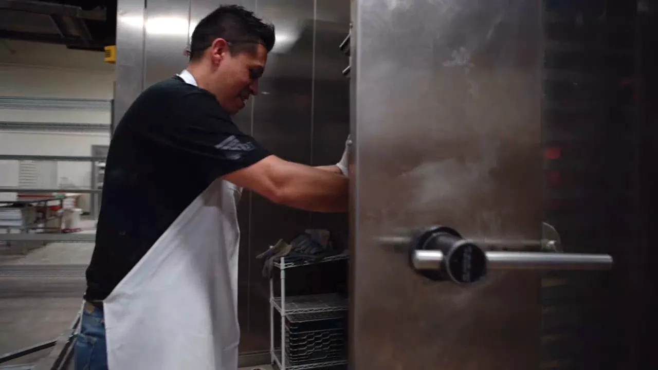 A baker at the oven door